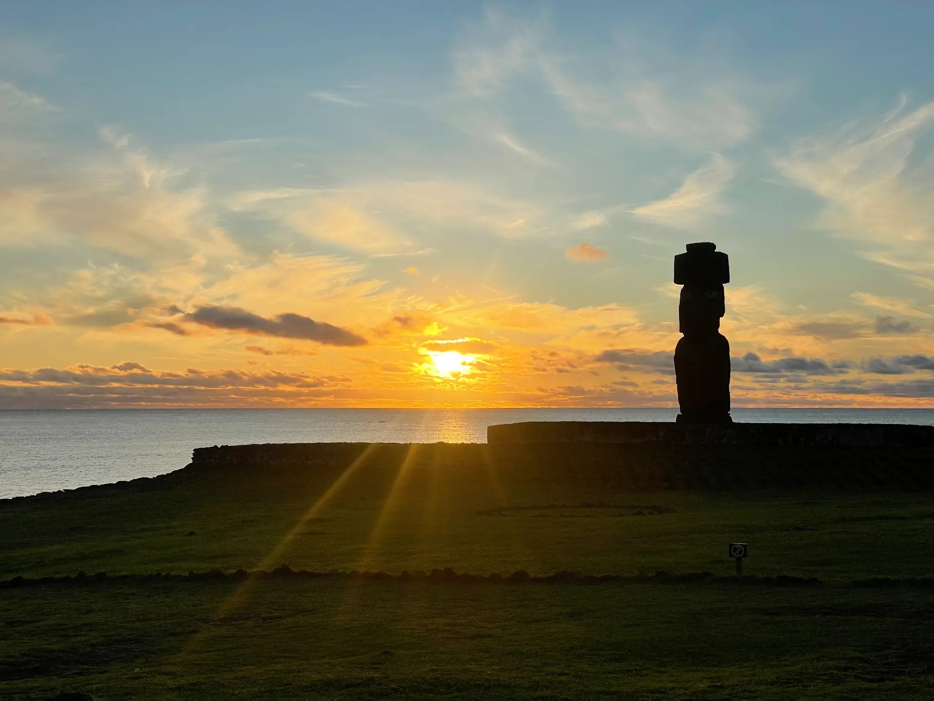 A moai with a topknot silhouetted against the sunset at Tahai