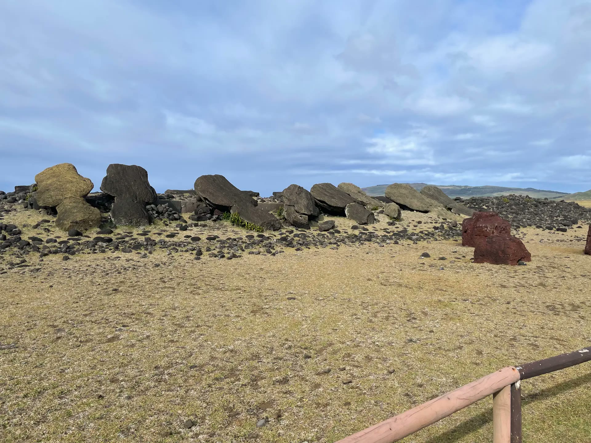 Fallen moai lying along the platform at Vaihu with red topknots beside them